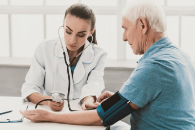 Young Female Doctor Examining Senior Patient